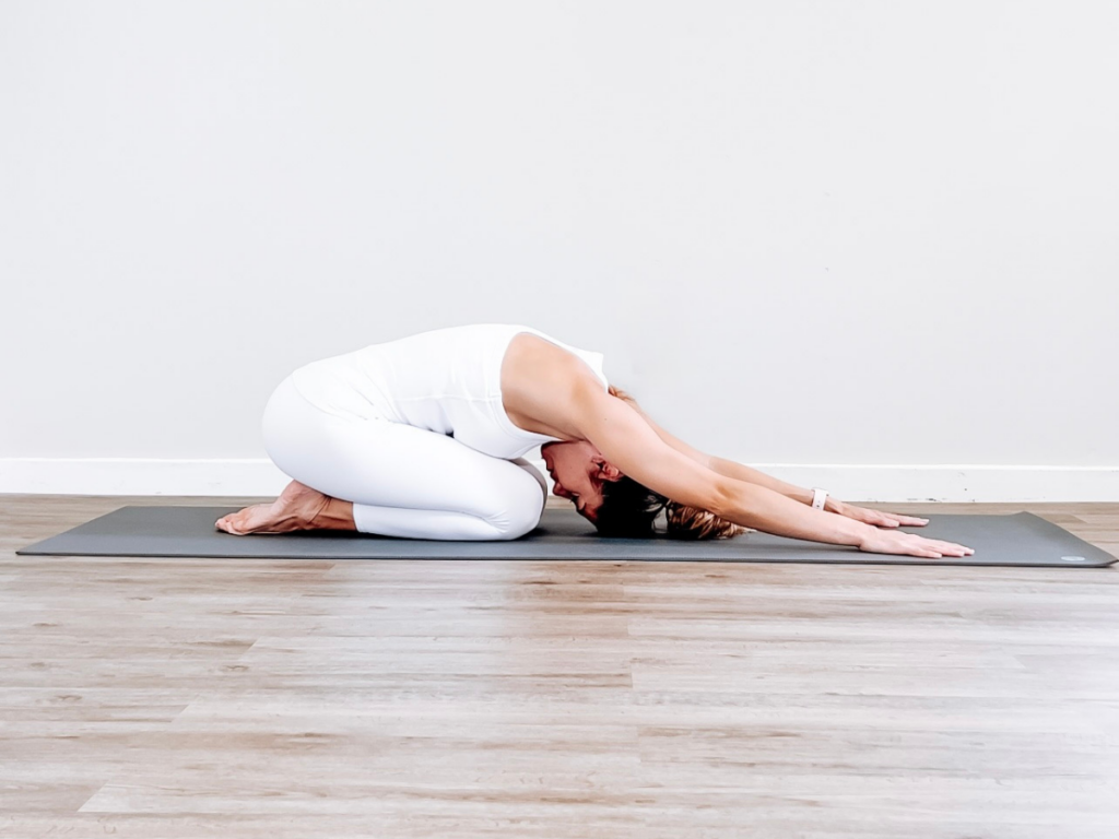 Calm female child sitting on mat in yoga pose with raised arms. Little girl  closed eyes and training Stock Photo by jeannierv